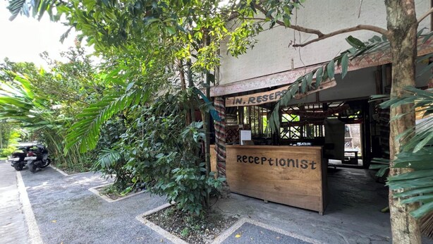 A reception desk labeled "RECEPTIONIST" with a sign above it reading "IN RESERVES". - OYO 94014 The Sanya Homestay (Mengwi)