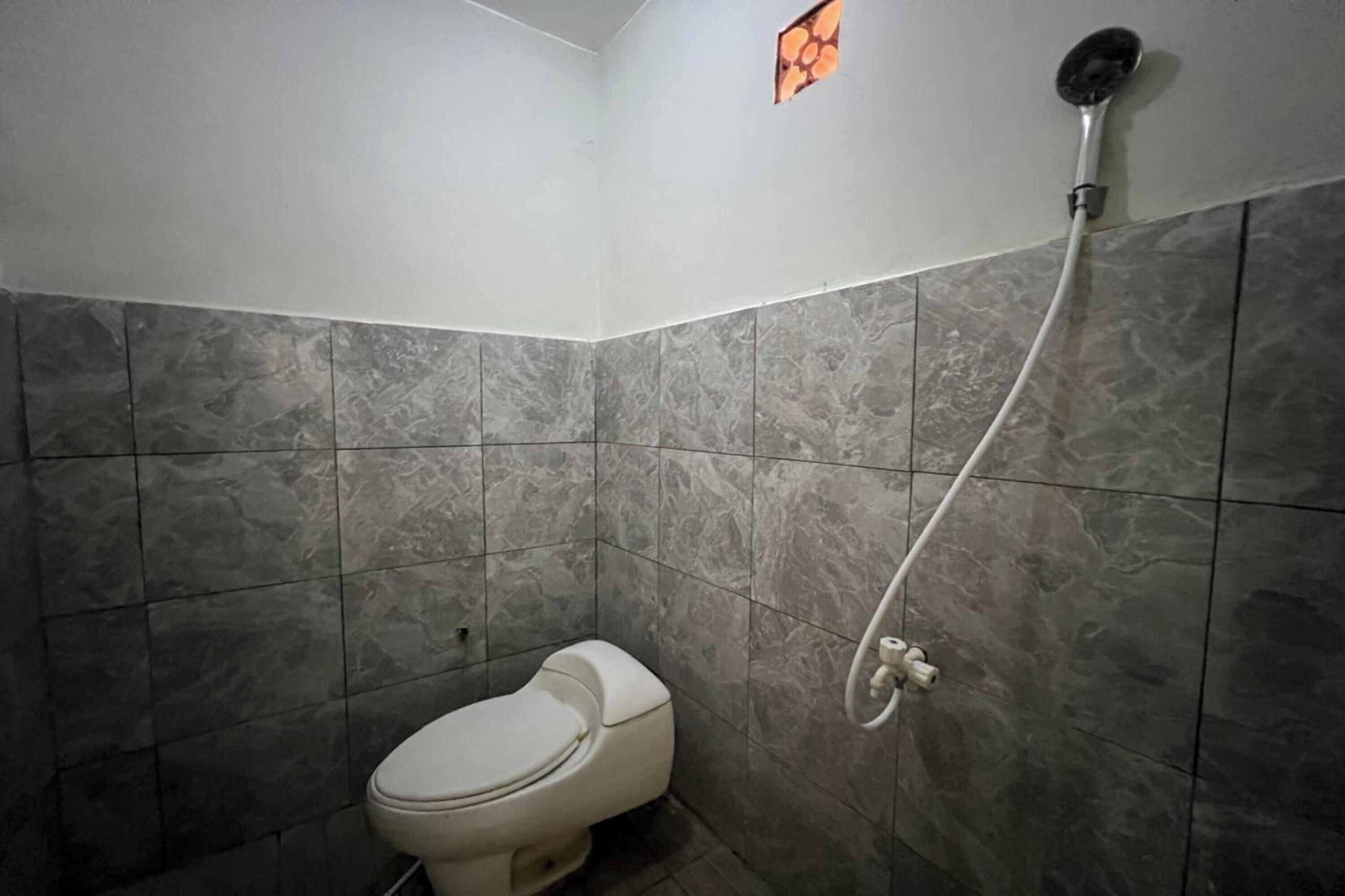 A bathroom with a toilet and a shower.