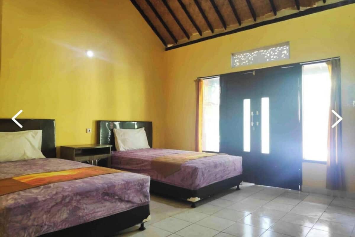 A room with two beds, a desk, and a door.