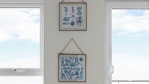 Ein Zimmer mit einem großen Fenster, einem gerahmten Meeresblick-Kunstwerk, einem gerahmten Meeresblick-Kunstwerk und einem runden Tisch mit Hut.