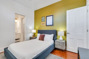A bedroom with a bed, bedside tables, a wardrobe, and a door.
