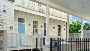 A two-story building with a covered porch and a blue door.