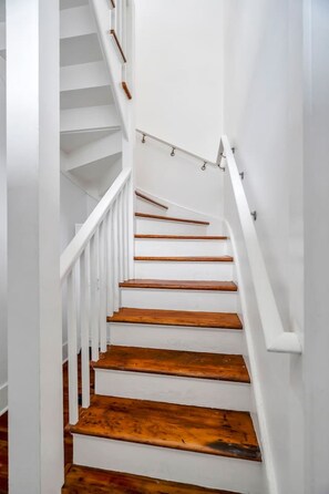 A white staircase with wooden steps and handrails.