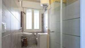 Moderni kylpyhuone, jossa on suihku, kaksi pesuallasta ja wc.