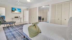 Une chambre d’hôtel moderne, dotée d’un grand lit, d’un bureau, d’une chaise et d’un téléviseur fixé au mur.