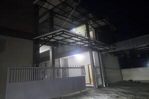A multi-level building with a balcony and a gated entrance. - Hotel O Guest House Pak Eman (Kertajati)
