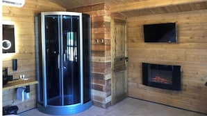 Un interior moderno con un ascensor de vidrio, chimenea y paredes de madera.