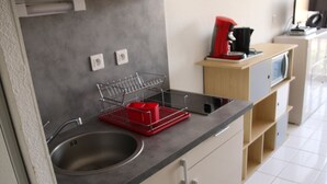 A kitchen with a stainless steel sink, a dish rack, and a coffee machine. - Charming Studio for 2 with Pool Access, Renovated, Parking, Near Beach (Cap d'Agde naturisme)