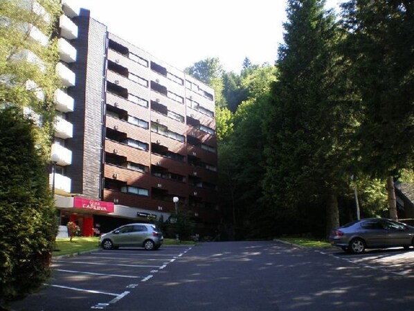 A multi-story parking garage with a red sign for a business named "CARLISLE". - Apartment in Mont-Dore with Private Parking - 4 people (Mont-Dore)