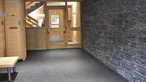 Een modern interieur met een stenen muur, houten deuren en een bank.