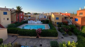 A residential area with a swimming pool surrounded by greenery and colorful buildings. - Studio Loft 4 people, Pool, Port Barcarès (Le Barcarès)