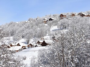 Ein verschneites Bergdorf mit Holzhäusern.