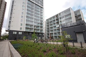 A modern apartment building with multiple floors, balconies, and a landscaped courtyard with greenery and bicycles. - Forenom Serviced Apts Espoo Matinkylä (Espoo)
