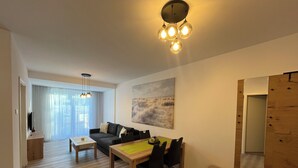 Ein modernes Wohnzimmer mit Essbereich, einem großen Spiegel und einem Bild an der Wand.