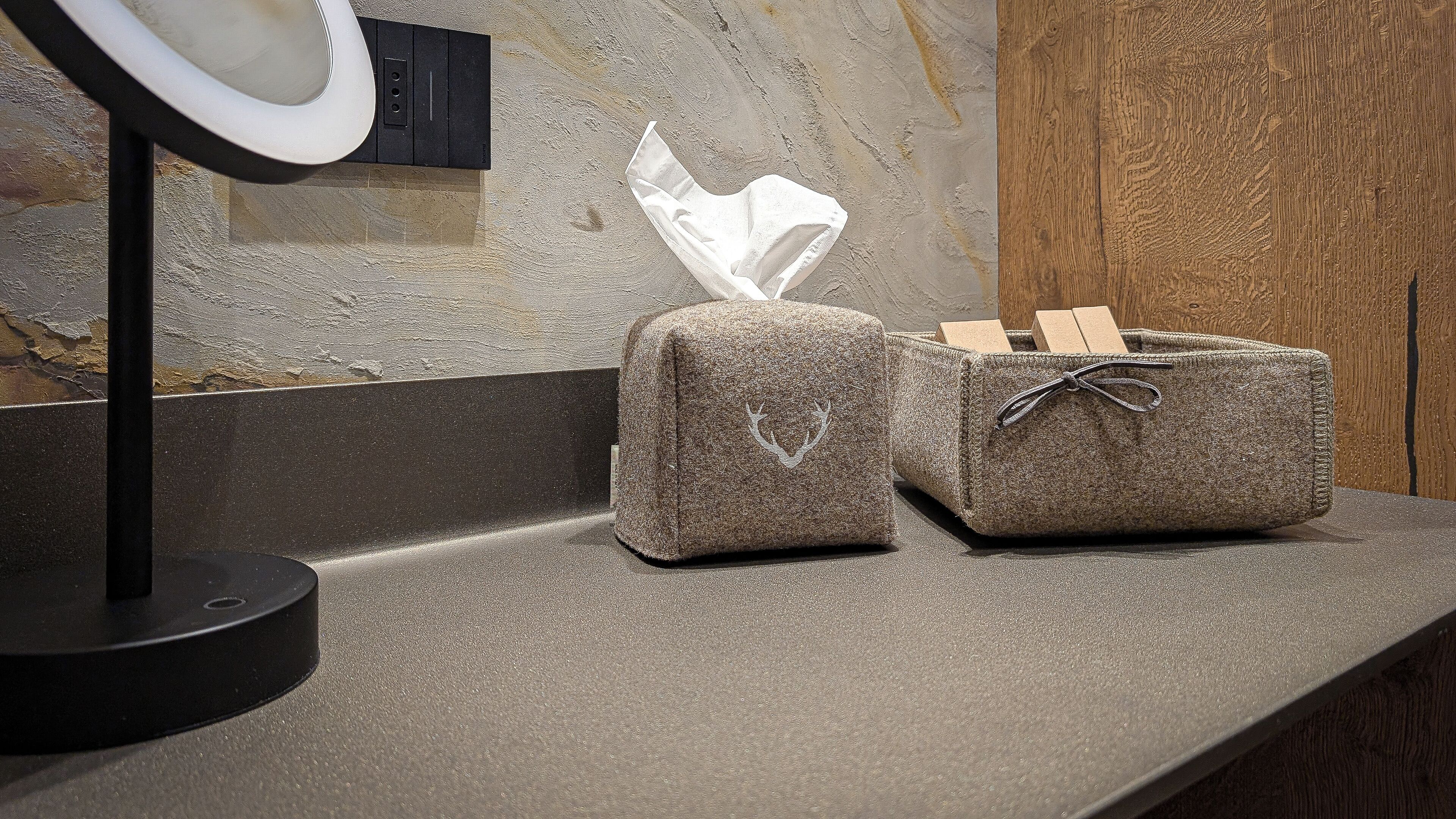 A bathroom vanity with a mirror, a towel dispenser, and a soap dish.
