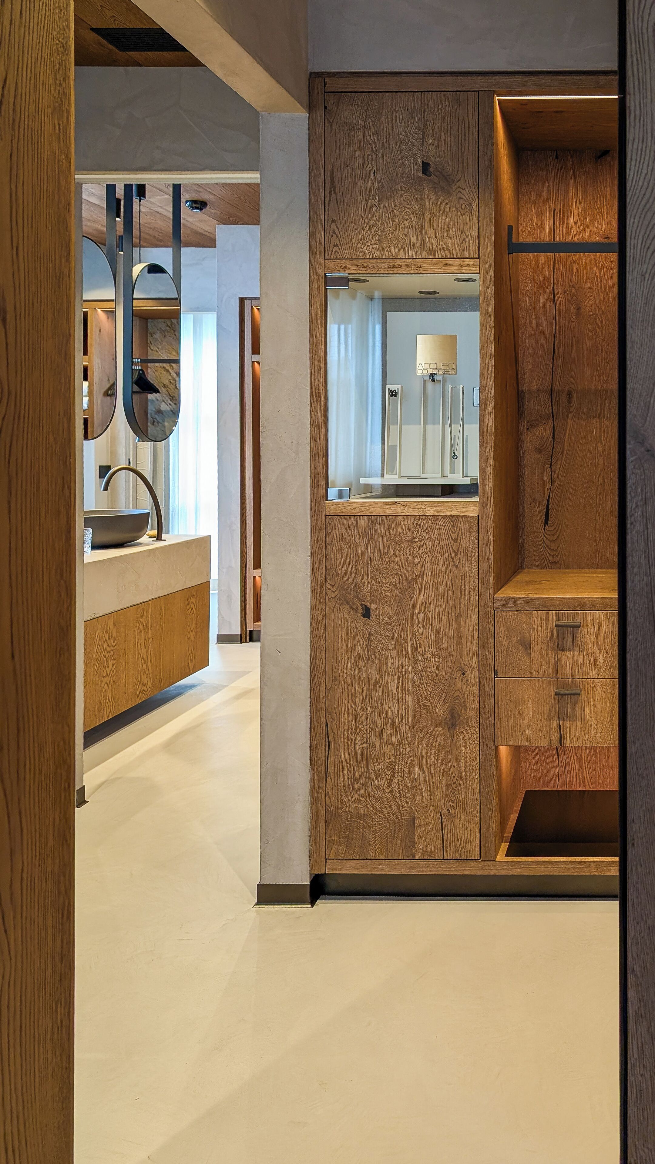 Una cocina moderna con una pared de madera decorativa, un lavamanos integrado y un espejo encima.