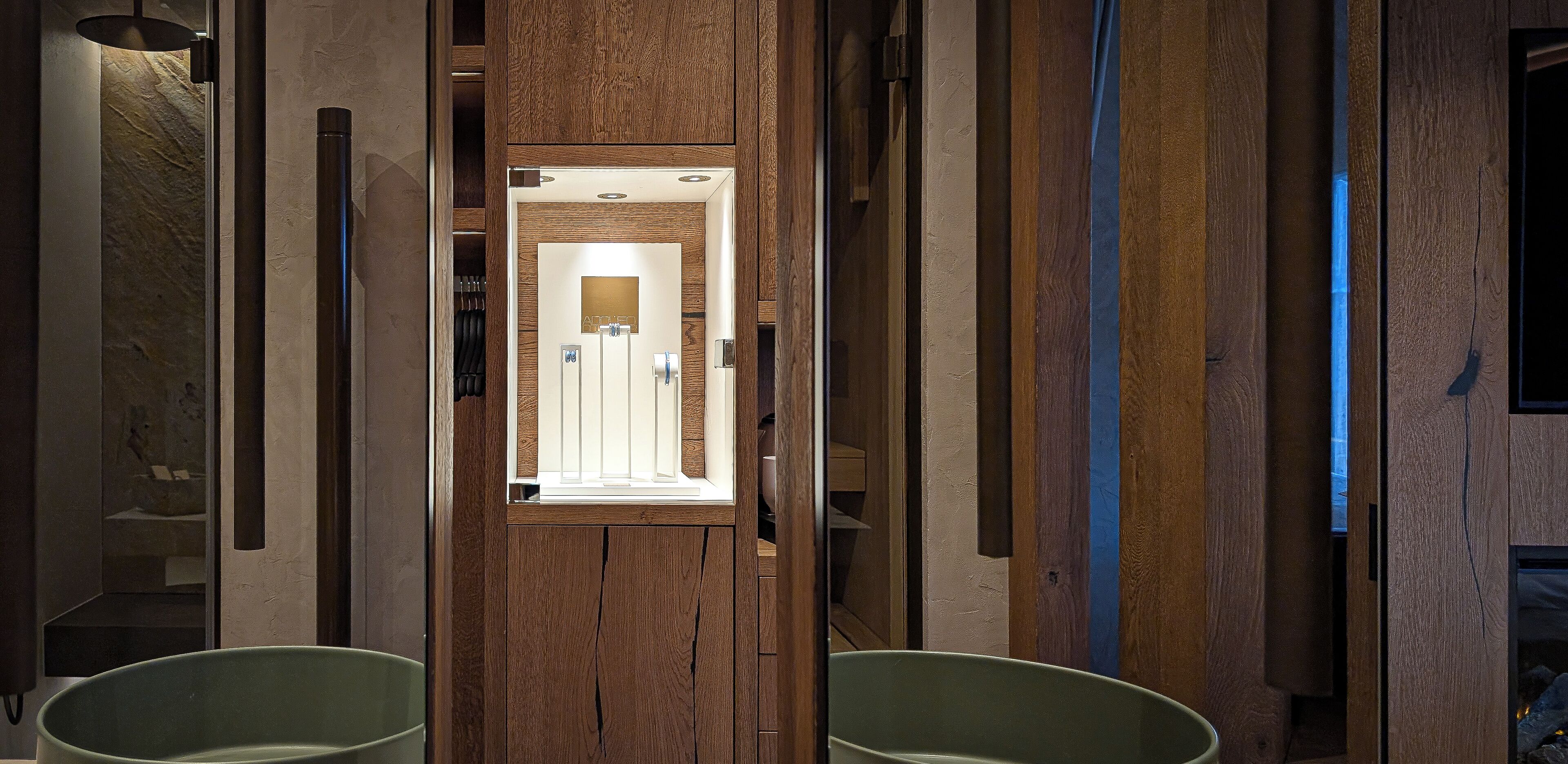 Un baño moderno con paneles de madera, un espejo y dos sillas verdes.