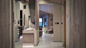A modern bathroom with a wooden vanity, a large mirror, and a towel rack.