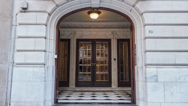 A grand entrance with a large arched doorway, a tiled floor, and a number plaque on the wall. - Hestia at Gral. Las Heras 1700 (Buenos Aires)