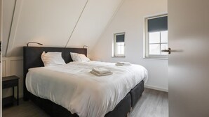 Una camera da letto con un letto grande, un comodino, una finestra e una porta.