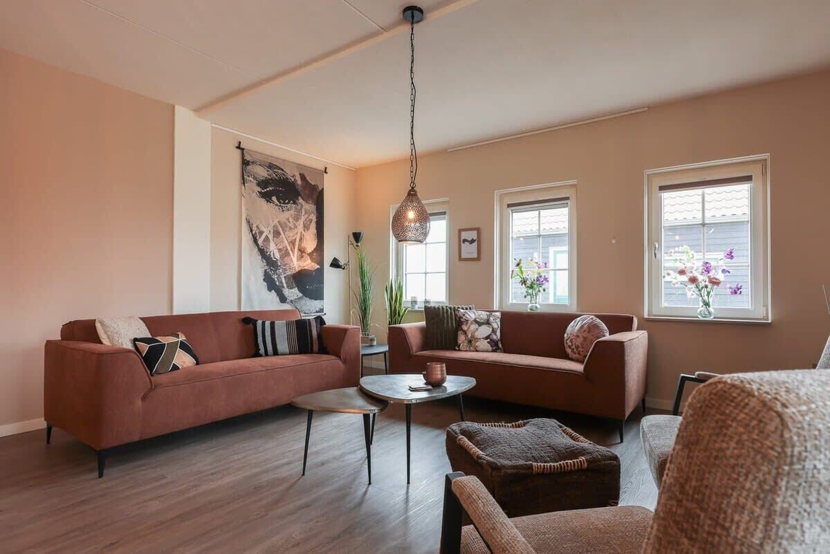 A living room with two sofas, a coffee table, and a hanging light fixture.