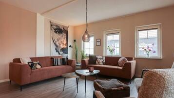 A living room with two sofas, a coffee table, and a hanging light fixture.
