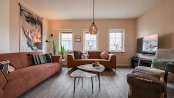 A modern living room with a sofa, coffee table, and a television.