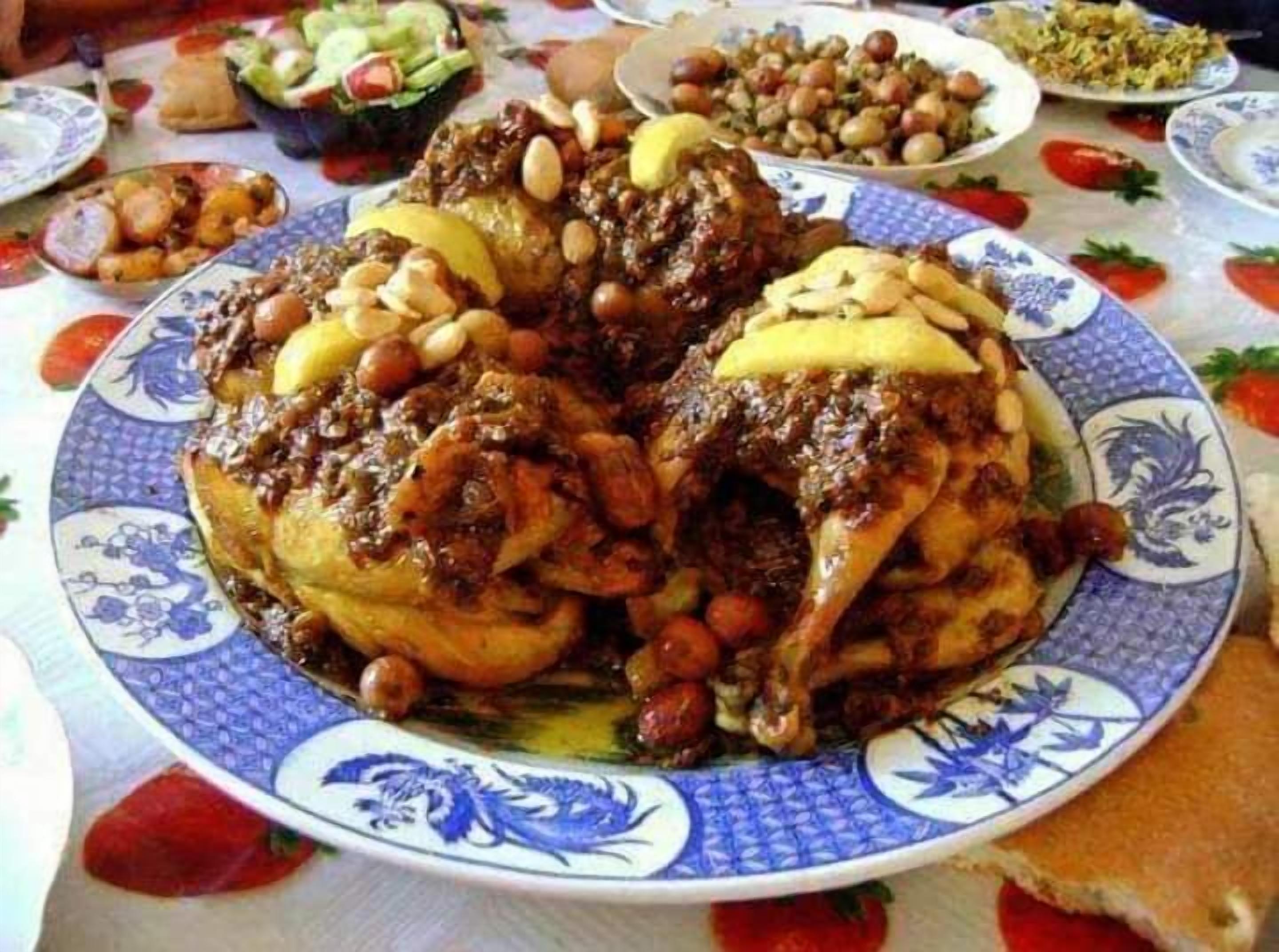 Un piatto di pollo arrosto con noci e salsa, circondato da diversi contorni.