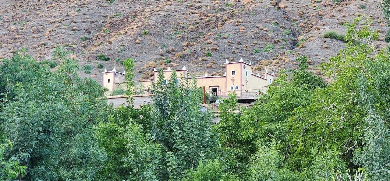 Un edificio de techo plano y dos torres, rodeado de exuberante follaje verde.