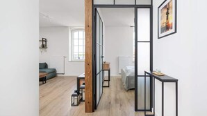 A modern living space with a wooden floor, a sofa, a coffee table, and a framed picture on the wall.