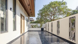 A modern building with a reflective black floor, large windows, and a wooden ceiling. - Lime Tree B&B Pari Chowk (Greater Noida)