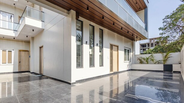 A modern building with a polished floor, large windows, and a wooden ceiling. - Lime Tree B&B Pari Chowk (Greater Noida)