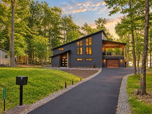 A modern two-story house with a driveway leading to a garage.
