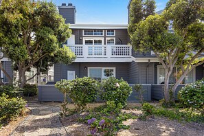 A two-story house with a balcony, surrounded by trees and a garden. - Trackside Tides - Pet Friendly - Racetrack and Lagoon Views - Extended Living (Del Mar)