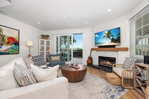 A living room with a sofa, coffee table, and a fireplace.