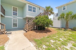 A two-story building with a wooden staircase leading to the entrance. - Bahama West by Panhandle Getaways (Panama City Beach)