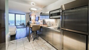 Una cocina moderna con electrodomésticos de acero inoxidable, una barra y vistas a la ciudad.