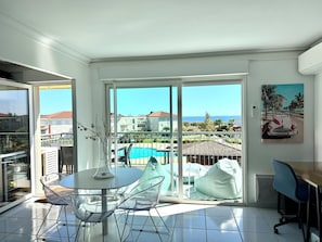 Enjoy a view of the swimming pool and coastal landscape from the balcony of this apartment.