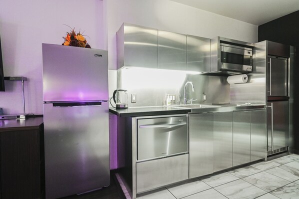 A modern kitchen with stainless steel appliances, a built-in oven, and a microwave.