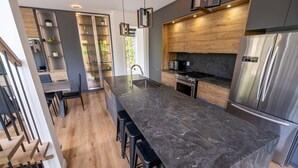 Una cucina moderna con un piano di lavoro in marmo, elettrodomestici in acciaio inossidabile e mobili in legno.