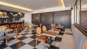 Un restaurant moderne avec un sol à carreaux, des chaises et des tables en bois.