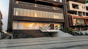 Un hôtel moderne, reconnaissable à son enseigne bien visible, doté de plusieurs étages et d’un escalier menant à l’entrée.