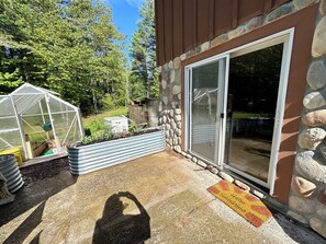 A greenhouse, a stone wall, and a door with a doormat. - Whitefish Walkout-walk to Lake Superior Beach! (Paradise)
