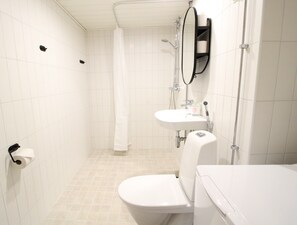 Baño con inodoro, lavabo y ducha.