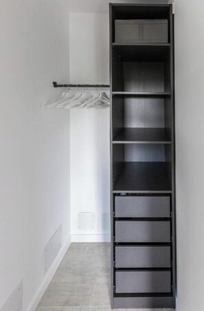 Storage area with shelving unit and vent.