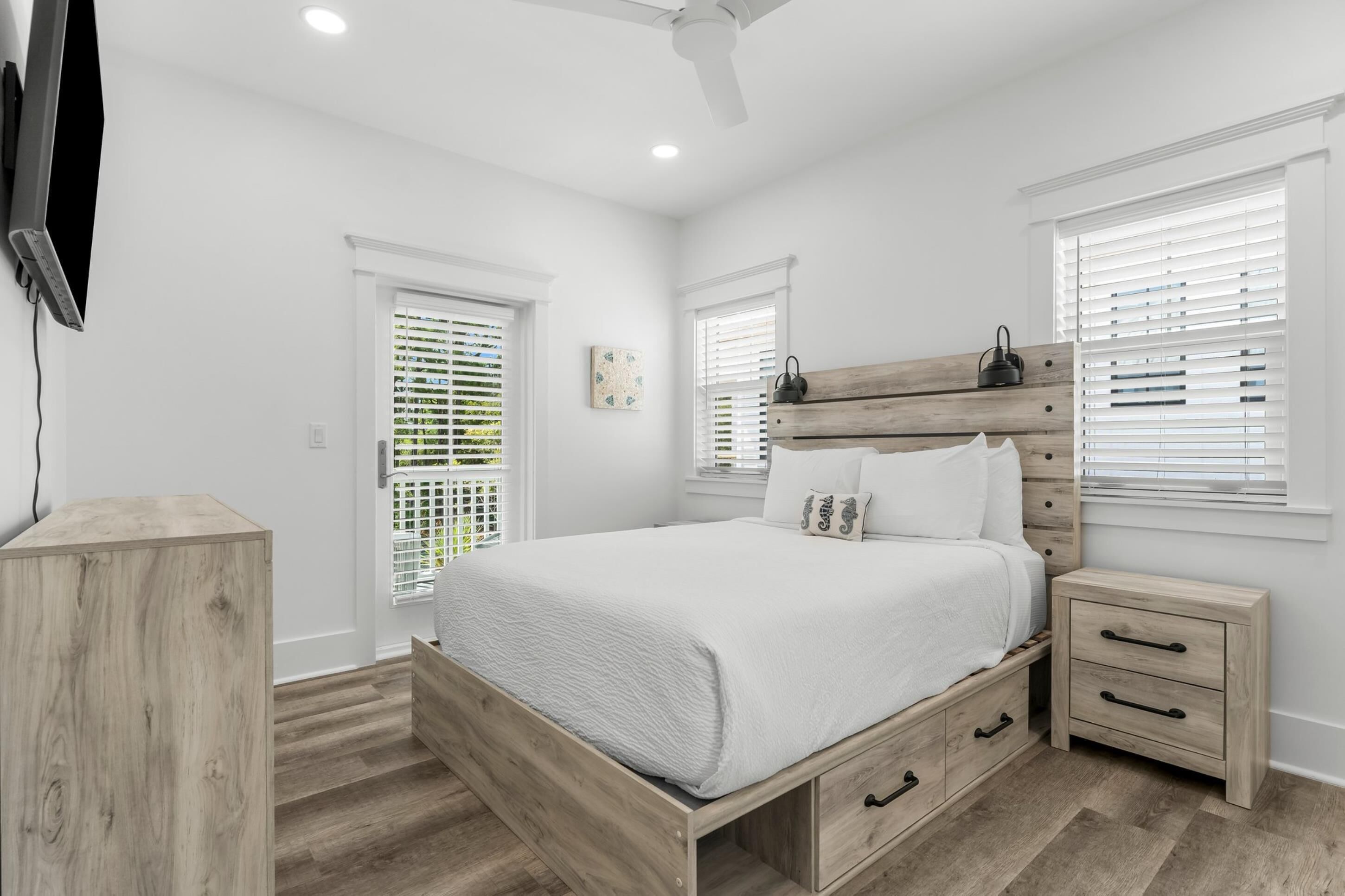 A bedroom with a wooden bed, bedside tables, and a ceiling fan.