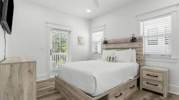 A bedroom with a wooden bed, bedside tables, and a ceiling fan.