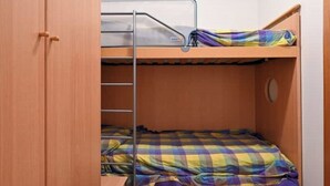 A bunk bed with a metal ladder and a checkered blanket. - VERA CRUZ 103 (Lido di Jesolo)