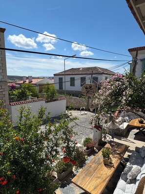 A courtyard with a wooden table, potted plants, and a sign for Boulanger Hotel. - H&R Alaçatı Hotel (Cesme)