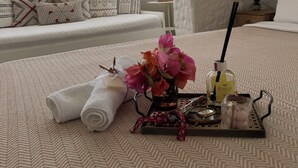 A bedroom with a large bed, a window with sheer curtains, a hanging light fixture, and a bedside table with a lamp. - H&R Alaçatı Hotel (Cesme)
